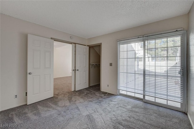 unfurnished bedroom with a textured ceiling, light carpet, and access to outside