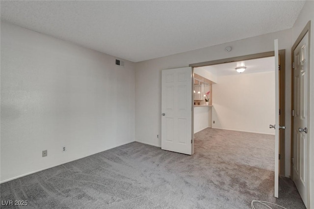 empty room featuring a textured ceiling and carpet flooring