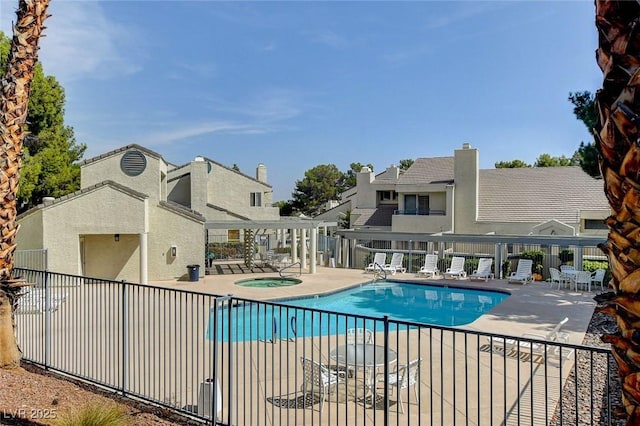 view of swimming pool with a hot tub and a patio