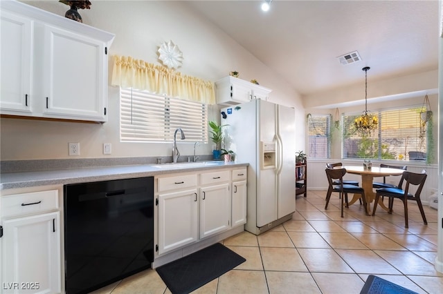 kitchen featuring white cabinets, dishwasher, white refrigerator with ice dispenser, sink, and hanging light fixtures