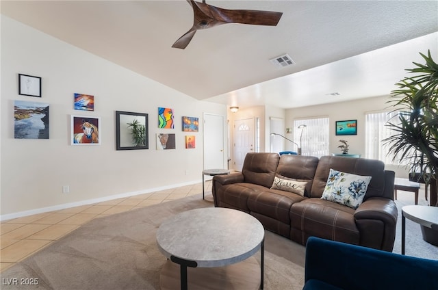 living room with ceiling fan, vaulted ceiling, and light tile patterned flooring