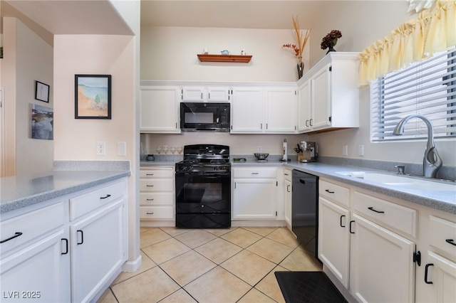 kitchen featuring black appliances, white cabinets, sink, and light tile patterned floors