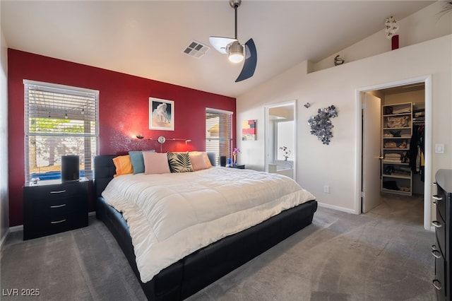 bedroom with ceiling fan, vaulted ceiling, a spacious closet, a closet, and dark carpet