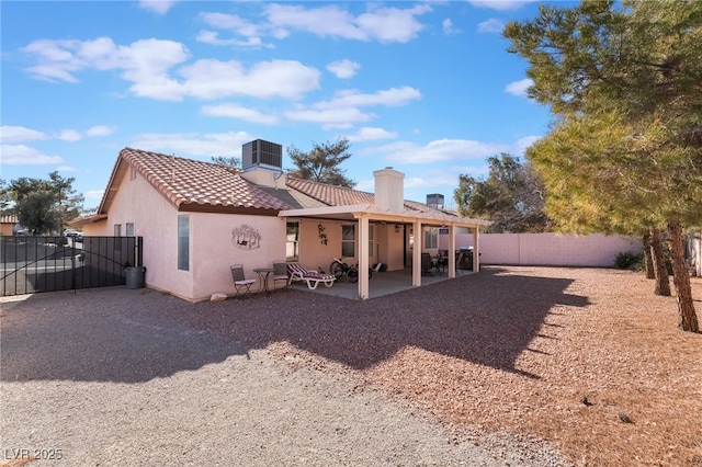 rear view of house with central air condition unit and a patio