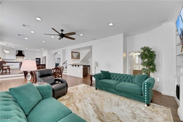 living room featuring ceiling fan and dark wood-type flooring