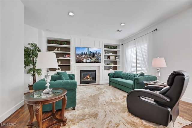 living room featuring hardwood / wood-style flooring and built in shelves