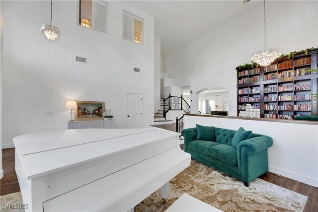 interior space featuring an inviting chandelier, dark hardwood / wood-style flooring, and a high ceiling