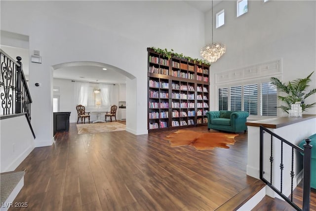 sitting room featuring an inviting chandelier, dark hardwood / wood-style flooring, and a towering ceiling