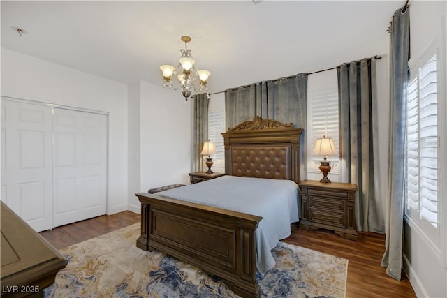 bedroom featuring dark hardwood / wood-style flooring, a closet, and a notable chandelier