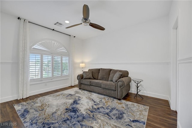 living room featuring ceiling fan and dark hardwood / wood-style flooring