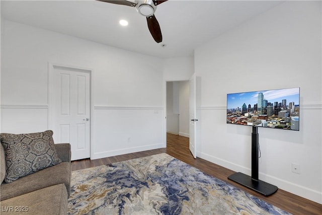 living area featuring ceiling fan and dark hardwood / wood-style flooring