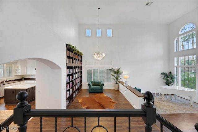 interior space with hardwood / wood-style flooring, sink, a chandelier, and a towering ceiling