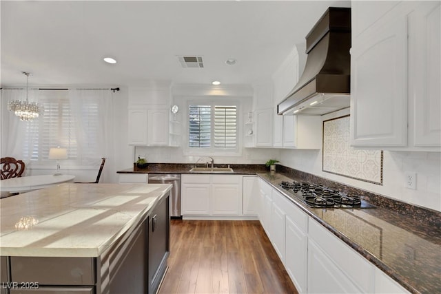 kitchen with appliances with stainless steel finishes, sink, white cabinets, and custom range hood