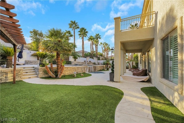 view of yard featuring a balcony and a patio