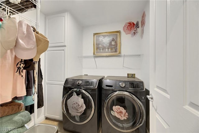 laundry area with washing machine and dryer and cabinets