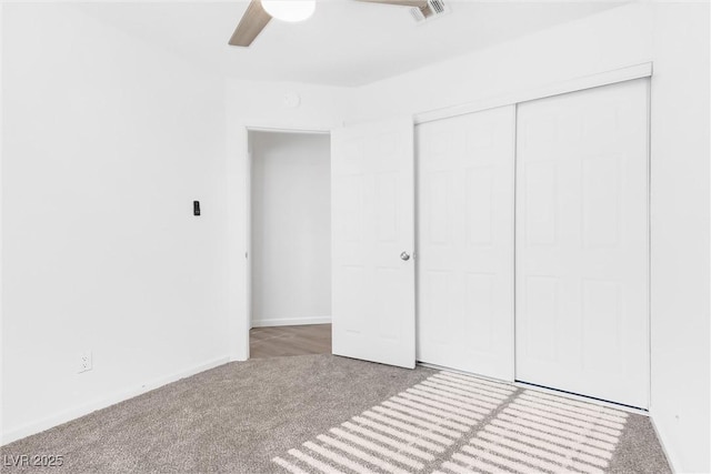 unfurnished bedroom with a closet, ceiling fan, and carpet flooring