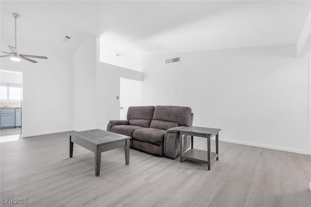 living room featuring light wood-type flooring, ceiling fan, and lofted ceiling