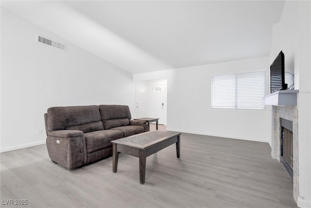 living room with light wood-type flooring and lofted ceiling