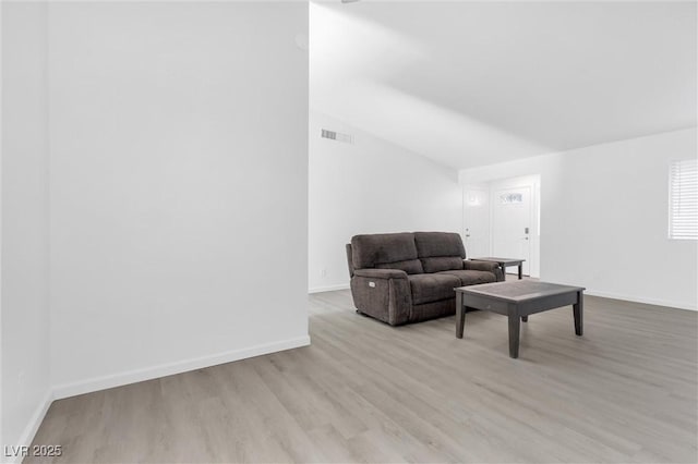 living room featuring light hardwood / wood-style flooring and vaulted ceiling