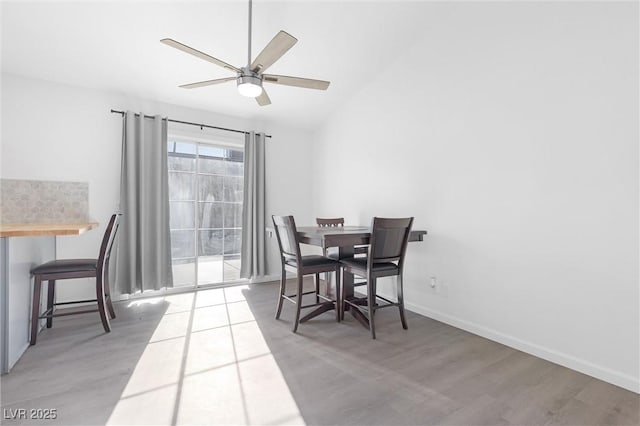 dining area with hardwood / wood-style flooring, ceiling fan, and lofted ceiling