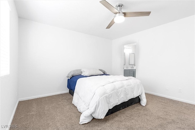 carpeted bedroom with ensuite bath and ceiling fan