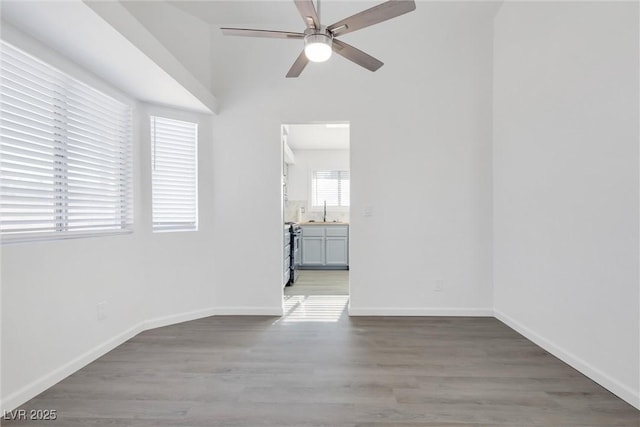 unfurnished room with hardwood / wood-style flooring, sink, and ceiling fan