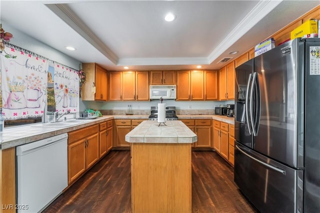 kitchen featuring a kitchen island, a raised ceiling, white appliances, ornamental molding, and dark hardwood / wood-style flooring