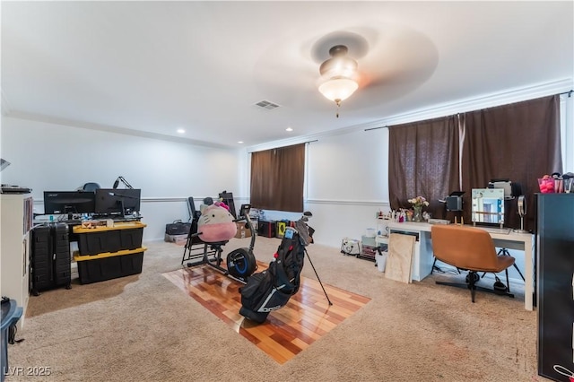 carpeted office space featuring ceiling fan and crown molding