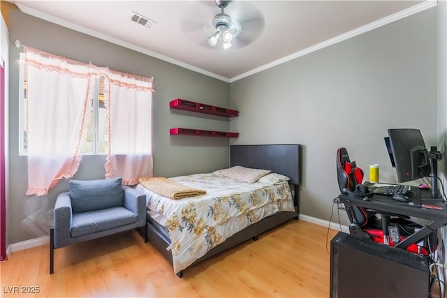 bedroom with ceiling fan, crown molding, and hardwood / wood-style flooring