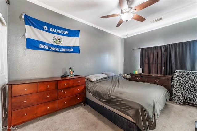 carpeted bedroom featuring ceiling fan and crown molding