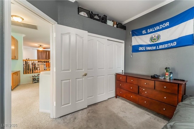 interior space featuring light colored carpet, a closet, and crown molding