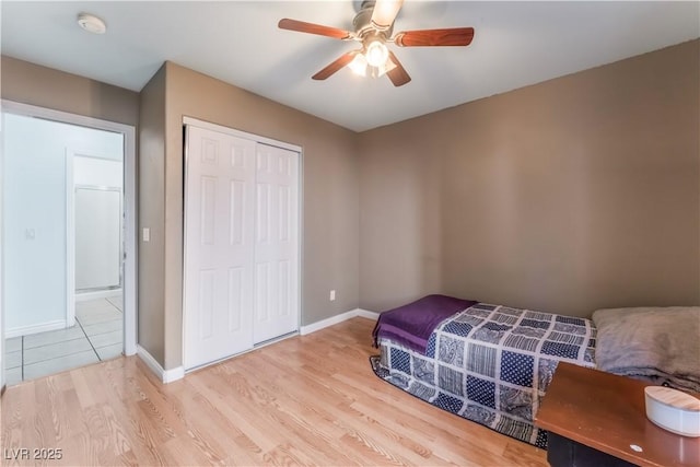 bedroom with ceiling fan, a closet, and light hardwood / wood-style flooring