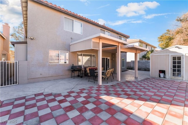 back of property featuring a storage unit and a patio