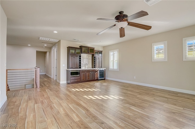 unfurnished living room with light hardwood / wood-style floors and beverage cooler