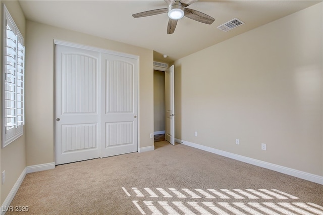 unfurnished bedroom with light carpet, a closet, and ceiling fan