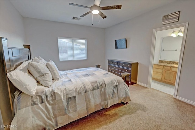 bedroom featuring ceiling fan, light colored carpet, and connected bathroom