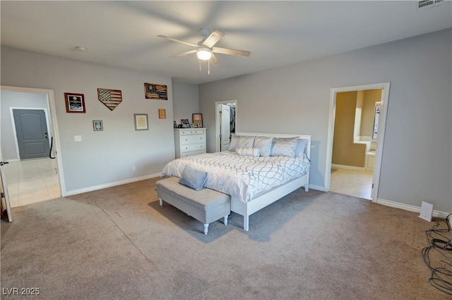 bedroom with ceiling fan, light carpet, and ensuite bathroom