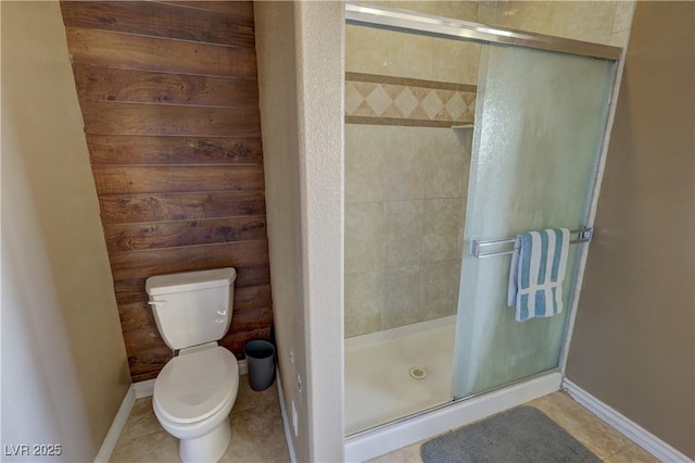 bathroom with toilet, tile patterned floors, and a shower with shower door