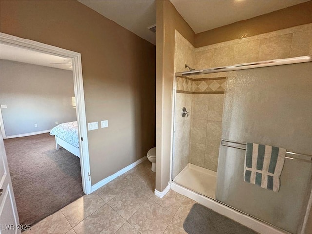 bathroom with tile patterned floors, a shower with door, and toilet