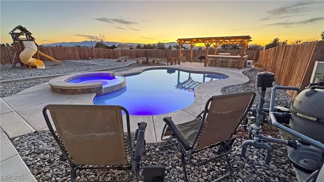 pool at dusk featuring a patio area, an in ground hot tub, and exterior bar