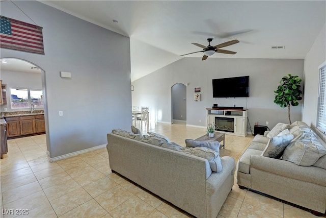 tiled living room with vaulted ceiling, ceiling fan, and sink