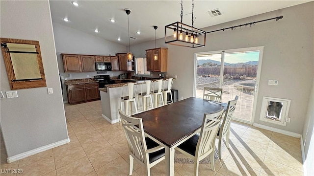 dining space featuring sink, vaulted ceiling, and light tile patterned flooring