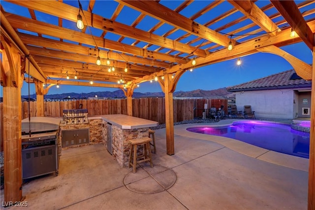 view of swimming pool with a pergola, a mountain view, a bar, a patio area, and area for grilling