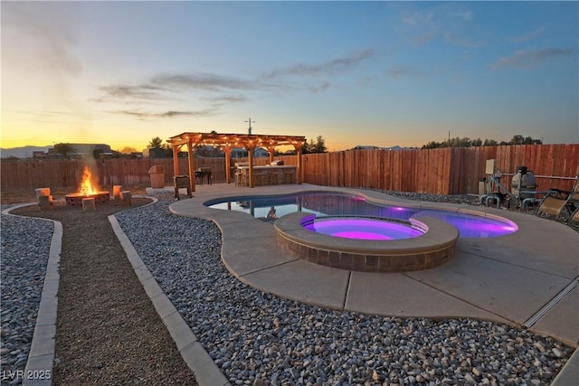 pool at dusk with a pergola, an in ground hot tub, a fire pit, and a patio