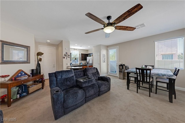 living room featuring light carpet, ceiling fan, and a wealth of natural light