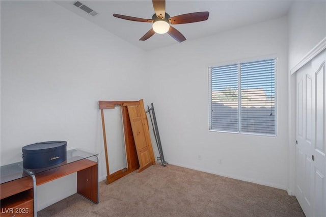 bedroom with ceiling fan, light colored carpet, and a closet