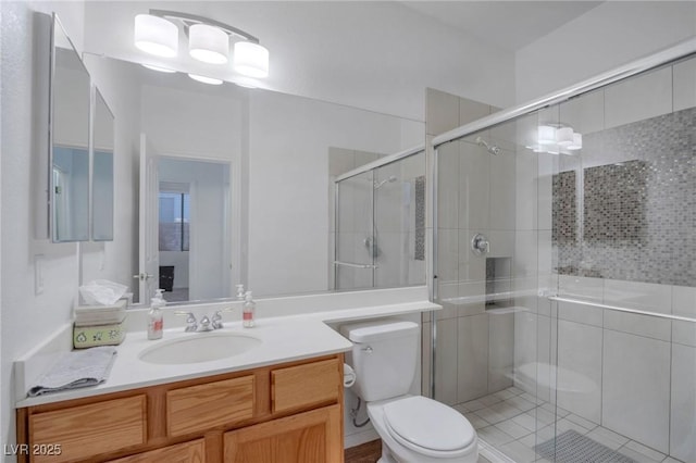 bathroom featuring toilet, vanity, and an enclosed shower