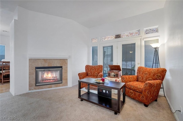 carpeted living room with vaulted ceiling and a fireplace