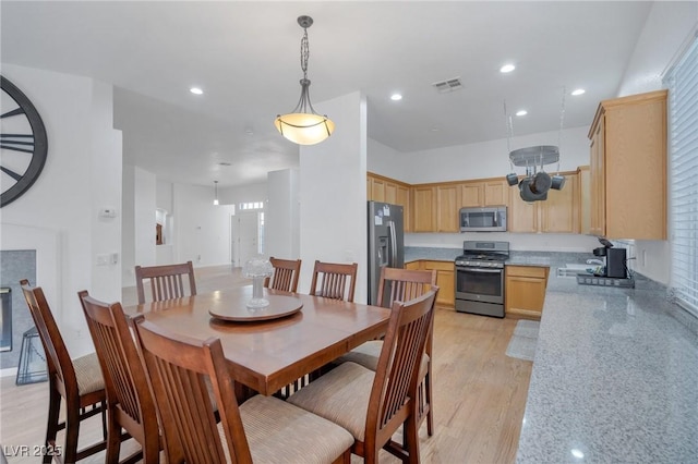 dining area with sink and light wood-type flooring