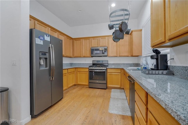 kitchen featuring light hardwood / wood-style floors, sink, appliances with stainless steel finishes, light brown cabinets, and light stone counters